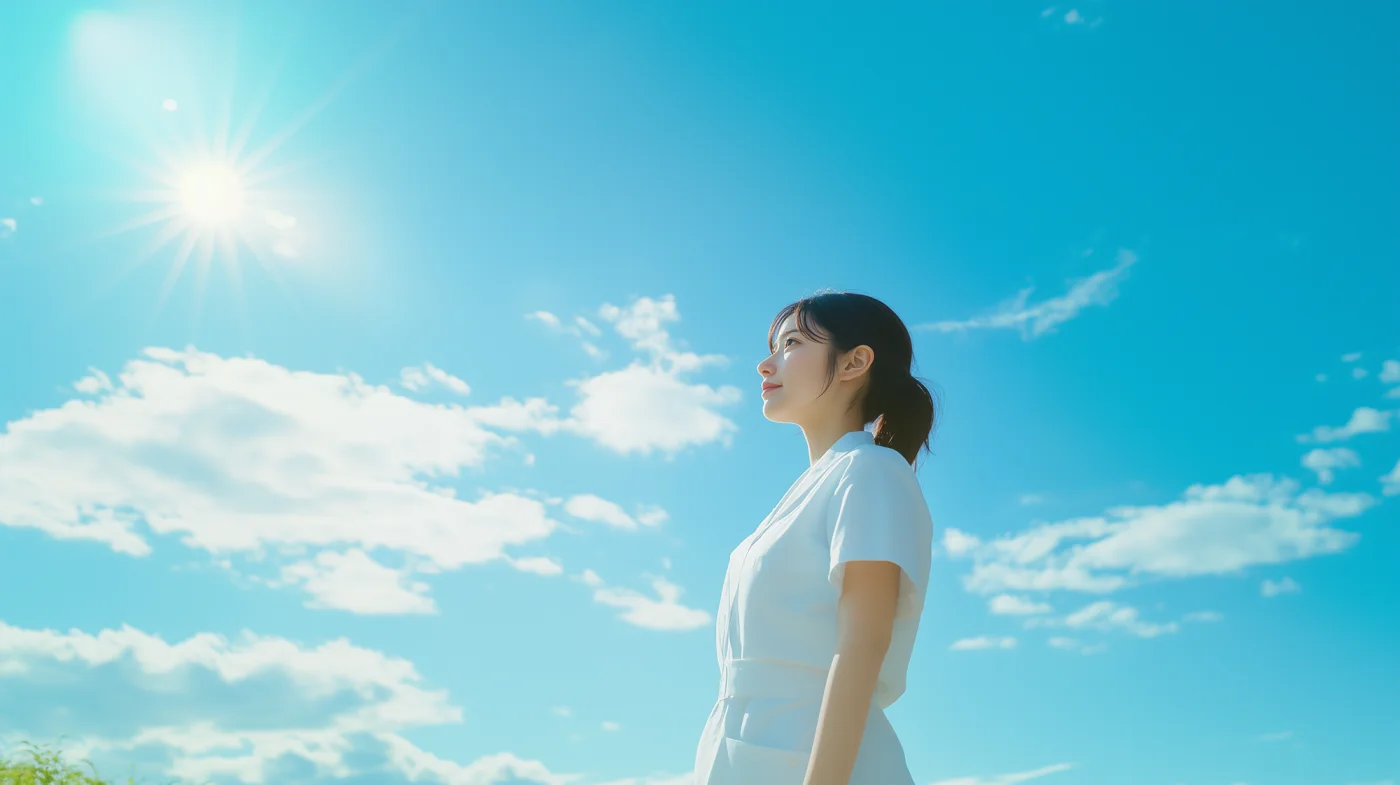 青空の下、白衣の女性。晴れやかな青空の下、白衣を着た女性が顔を上げ、希望に満ちた表情で遠くを見つめている。