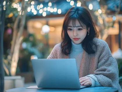 夜カフェでノートPC作業に集中する日本人女性